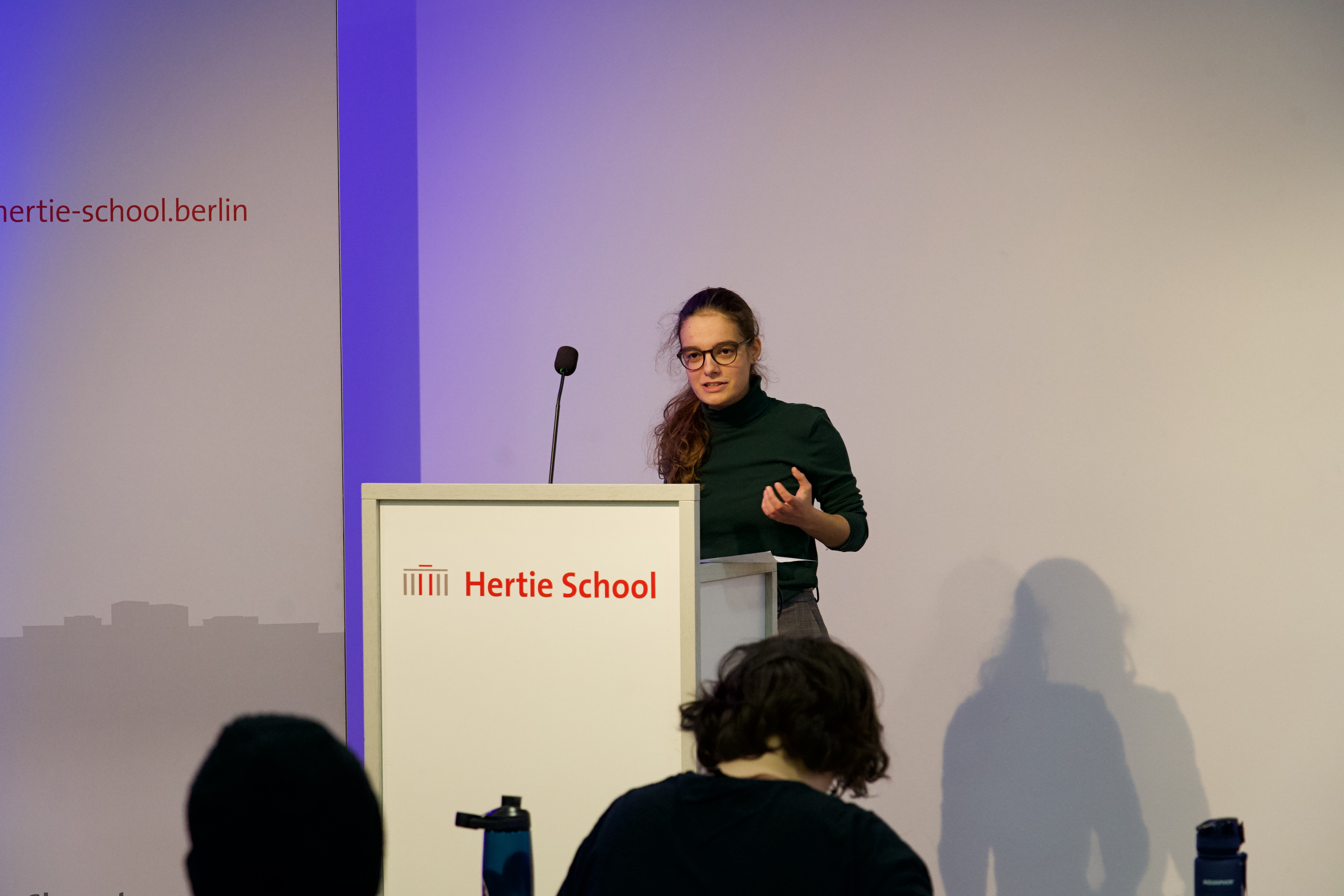Eine Rednerin beim Berlin Open gestikuliert am Rednerpult